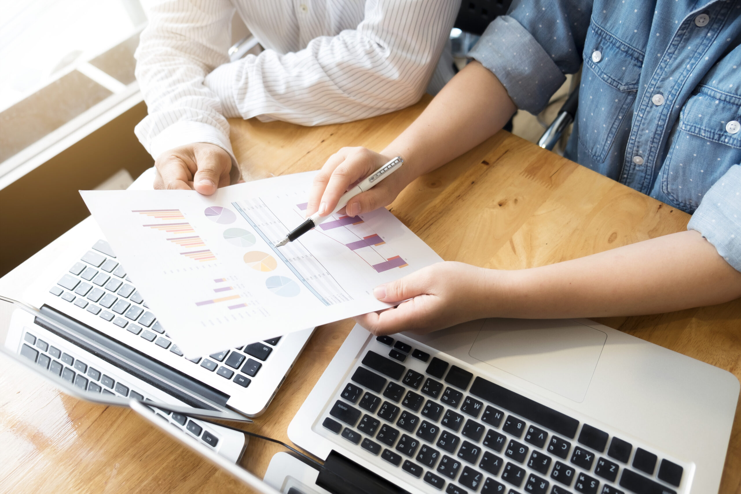 Dos personas reunidas analizando gráficos. Concepto de trabajo en equipo empresarial.